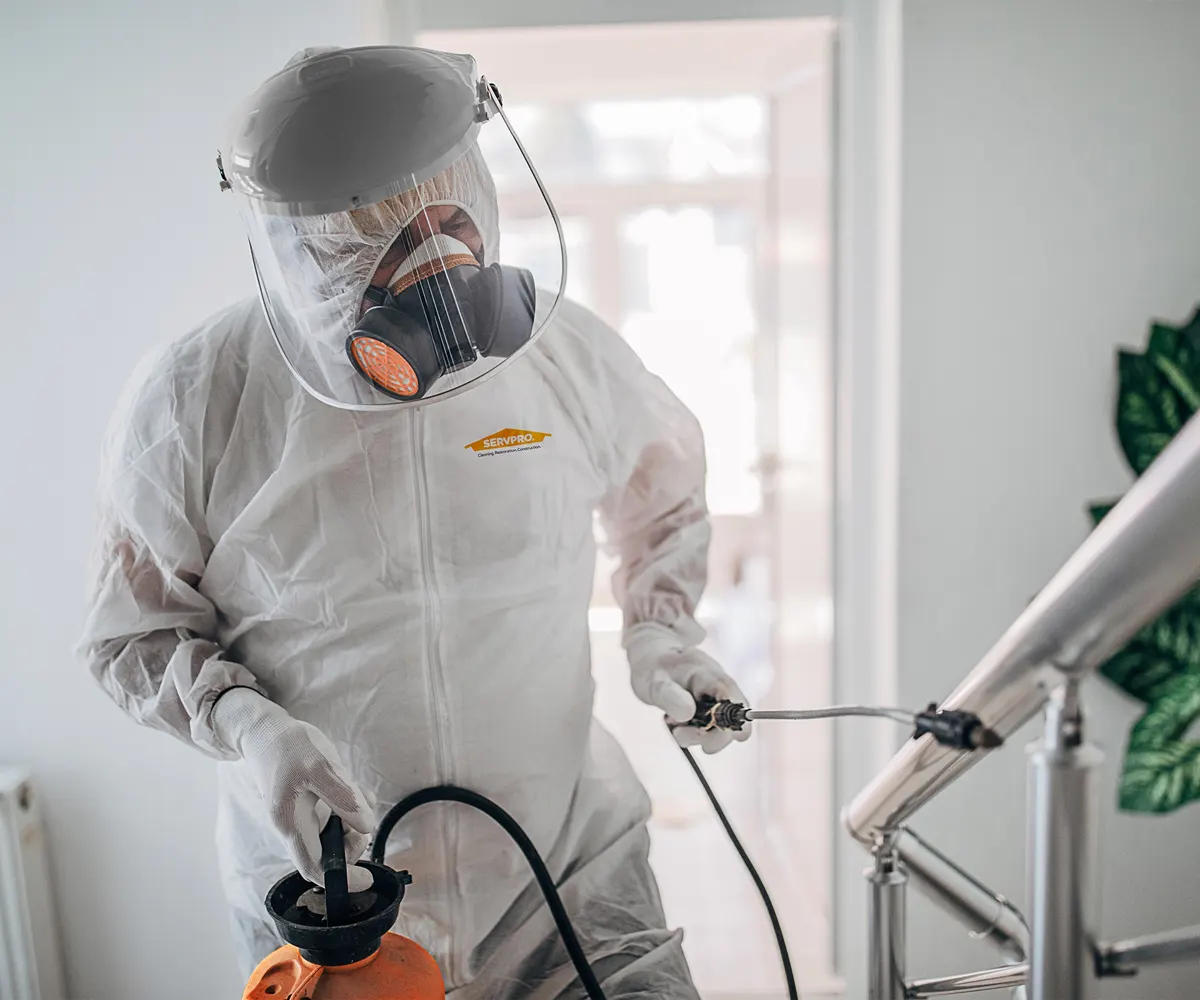 Specialist in beschermende kleding voert desinfectie uit