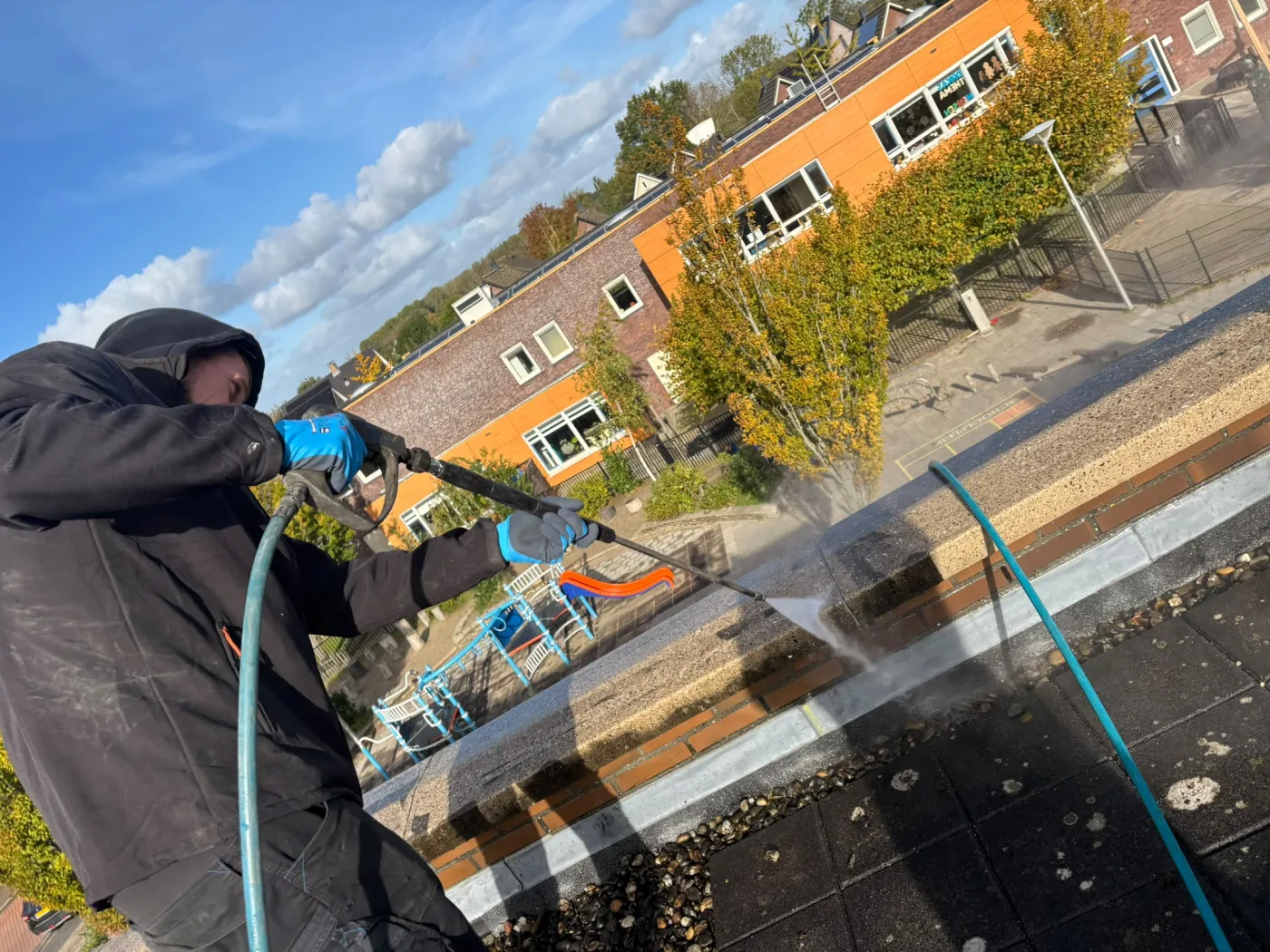 Specialist voert hogedrukreiniging uit op hoogte